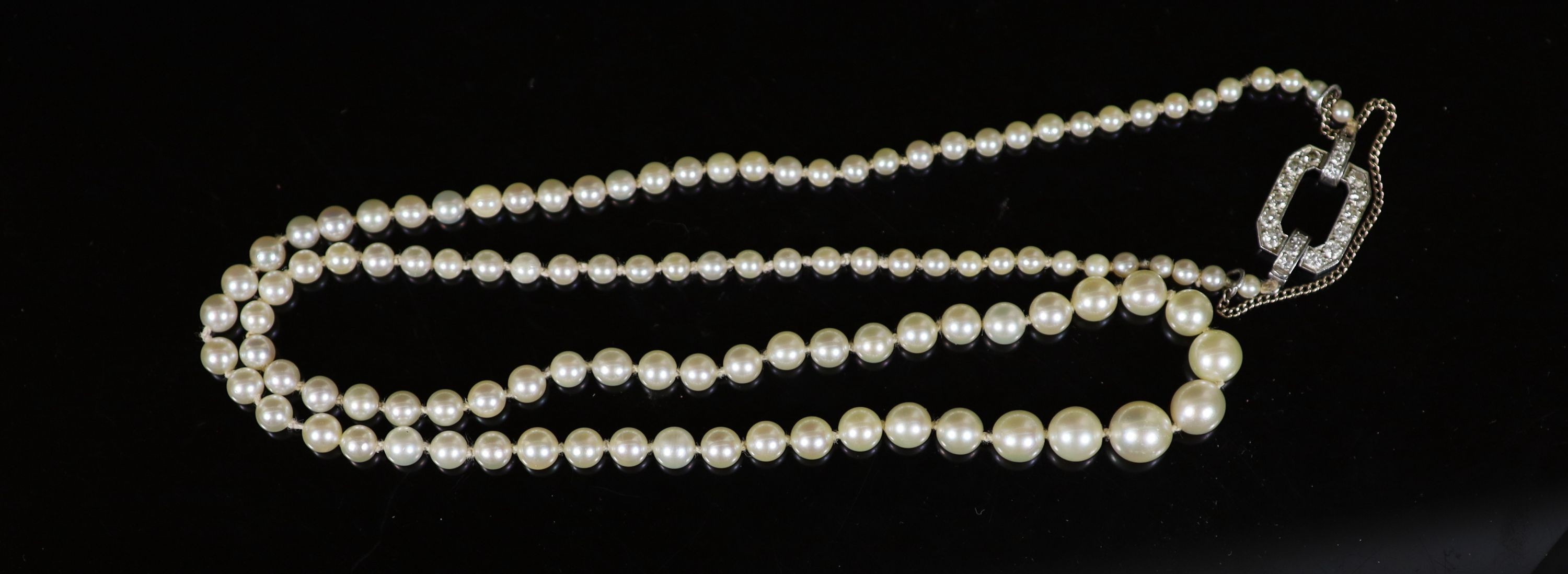 A mid 20th century single strand graduated pearl necklace, with platinum and diamond set open work clasp, signed Cartier with indistinct numbers